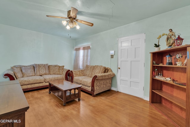 living room with light hardwood / wood-style flooring and ceiling fan