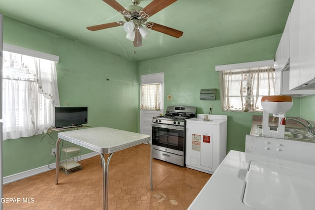 kitchen with ceiling fan, stainless steel range with gas cooktop, sink, and white cabinets