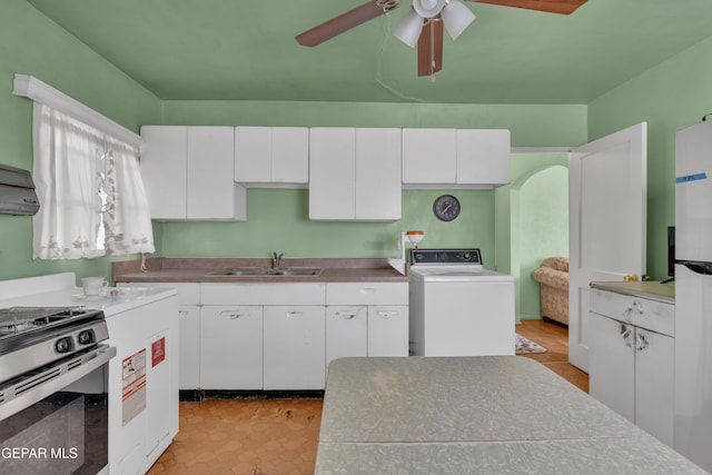 kitchen featuring washer / dryer, white cabinets, ceiling fan, sink, and stainless steel gas range