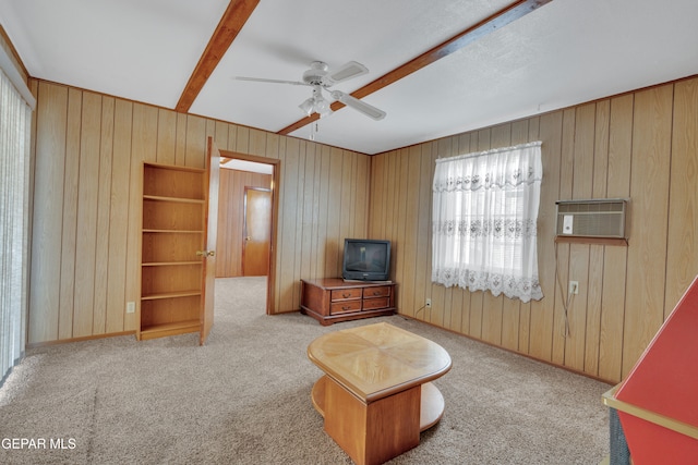 living room with wooden walls, light colored carpet, and ceiling fan