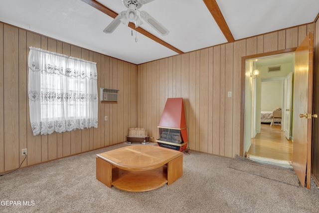 living area featuring light carpet, a wall mounted AC, wooden walls, and ceiling fan