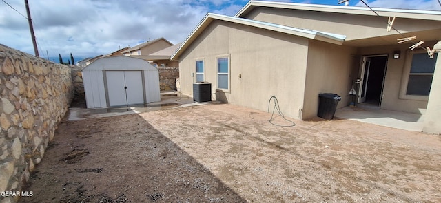 back of house with a patio area, cooling unit, and a shed