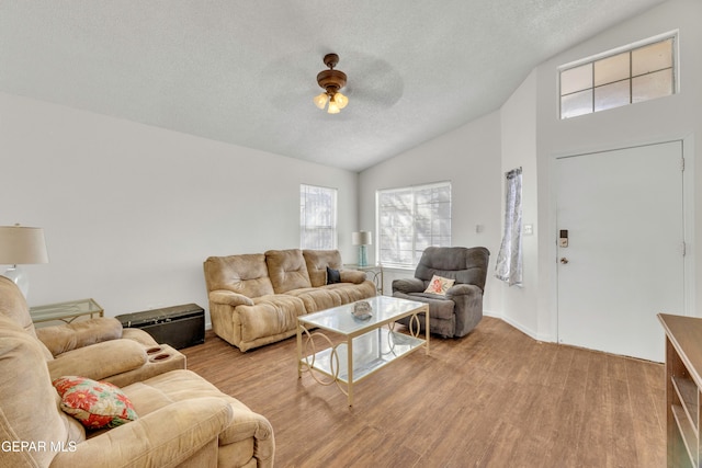 living room featuring light hardwood / wood-style floors, ceiling fan, and lofted ceiling