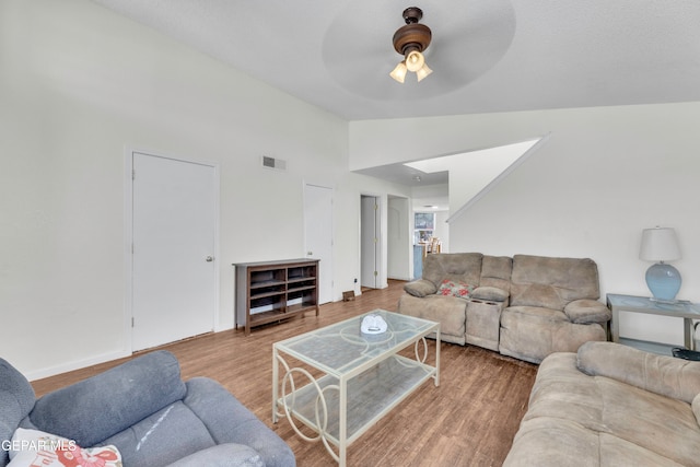 living room featuring hardwood / wood-style flooring, ceiling fan, and lofted ceiling