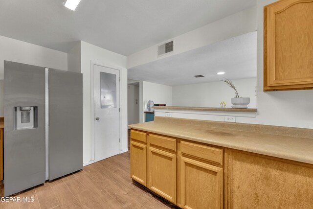 kitchen featuring light brown cabinets, stainless steel fridge, and light wood-type flooring