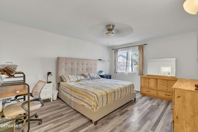 bedroom featuring a textured ceiling, hardwood / wood-style flooring, and ceiling fan