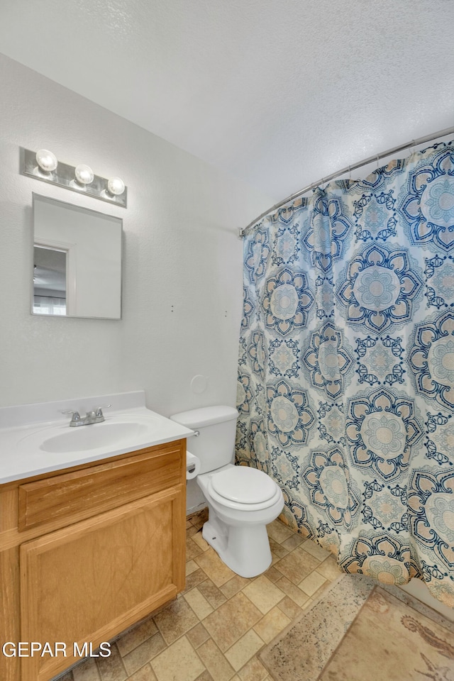 bathroom featuring a shower with shower curtain, vanity, and toilet