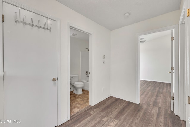 hallway featuring dark hardwood / wood-style flooring and a textured ceiling