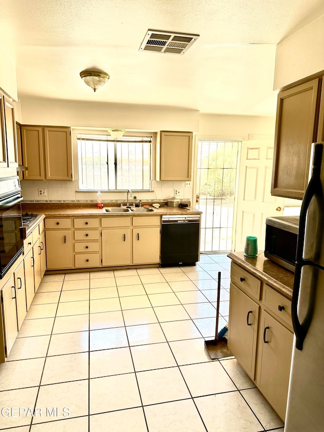 kitchen featuring stainless steel appliances, a textured ceiling, sink, and light tile patterned flooring