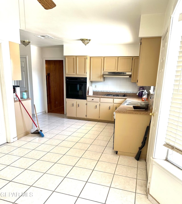 kitchen with tasteful backsplash, black oven, light brown cabinetry, gas stovetop, and sink