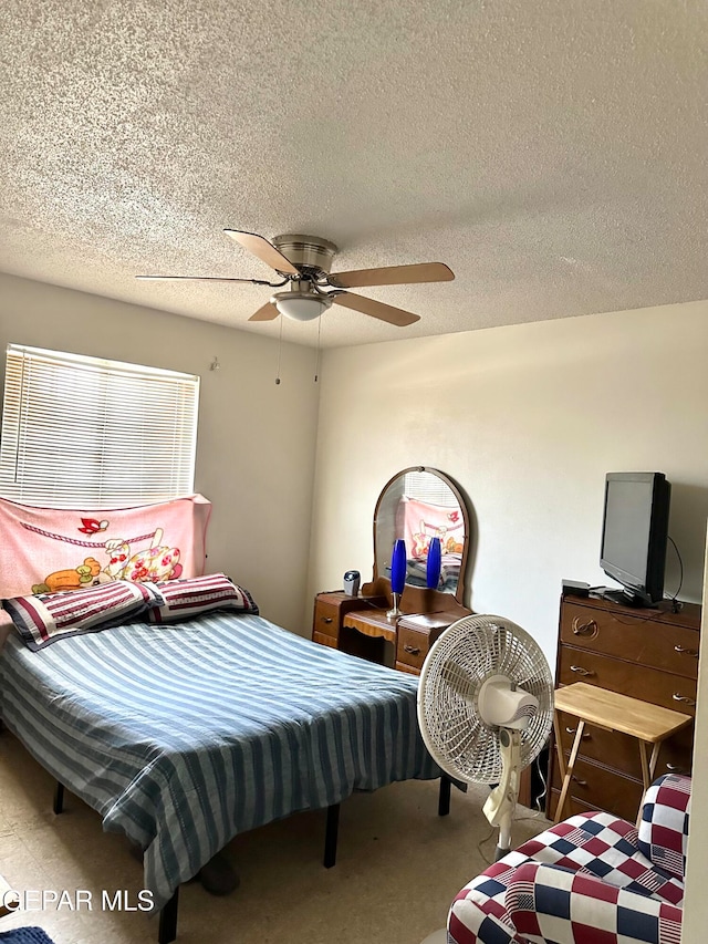 bedroom with a textured ceiling, carpet floors, and ceiling fan