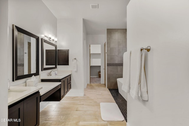 2300 Tierra Zaria, El Paso, TX 79938 - bathroom featuring two vanities, wood finished floors, a tile shower, and a freestanding bath