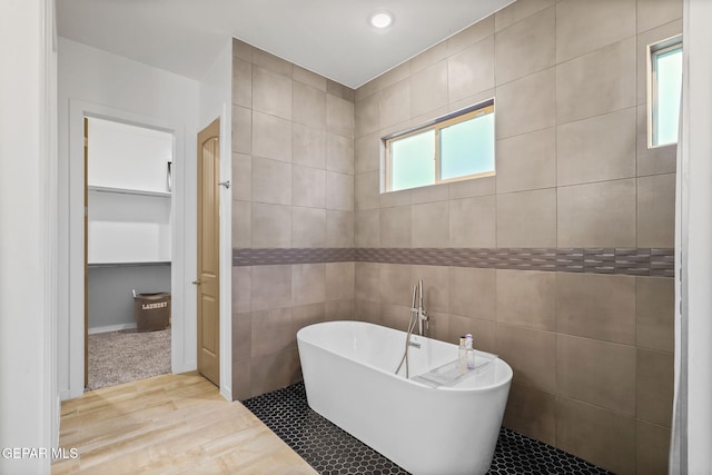 2300 Tierra Zaria, El Paso, TX 79938 - bathroom featuring a freestanding tub, wood finished floors, and tile walls
