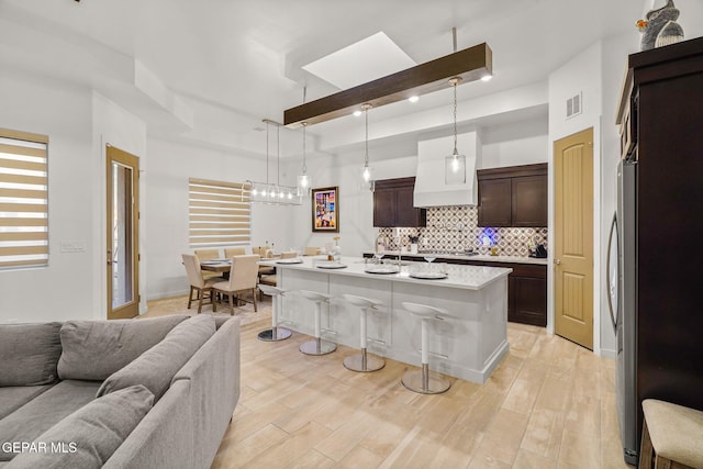 2300 Tierra Zaria, El Paso, TX 79938 - kitchen featuring open floor plan, a breakfast bar, backsplash, dark brown cabinets, and light countertops