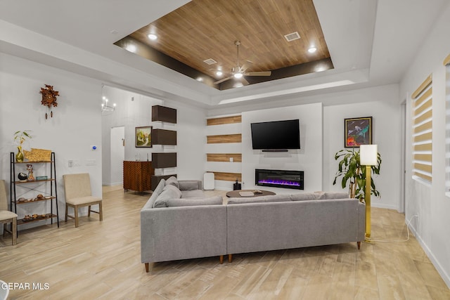 2300 Tierra Zaria, El Paso, TX 79938 - living room featuring a raised ceiling, ceiling fan, wood ceiling, a glass covered fireplace, and light wood-type flooring