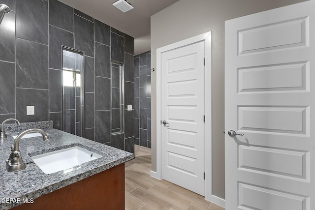 bathroom featuring vanity and tiled shower