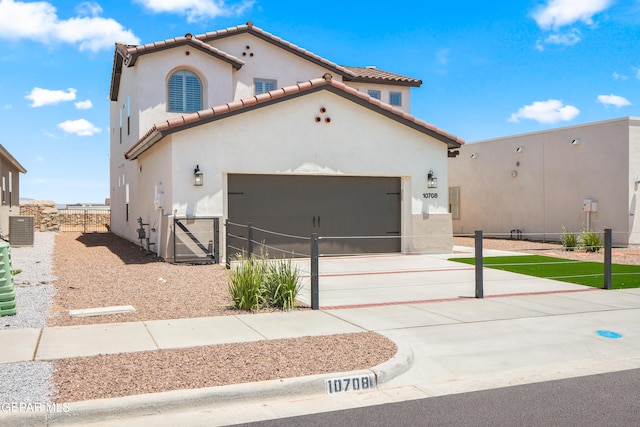 mediterranean / spanish-style home with central AC and a garage