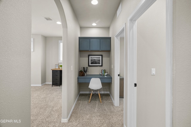 office area with built in desk and light carpet