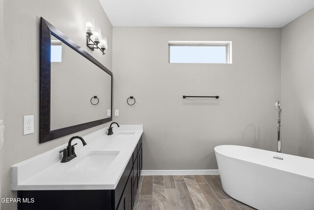 bathroom with vanity, hardwood / wood-style flooring, and a bath