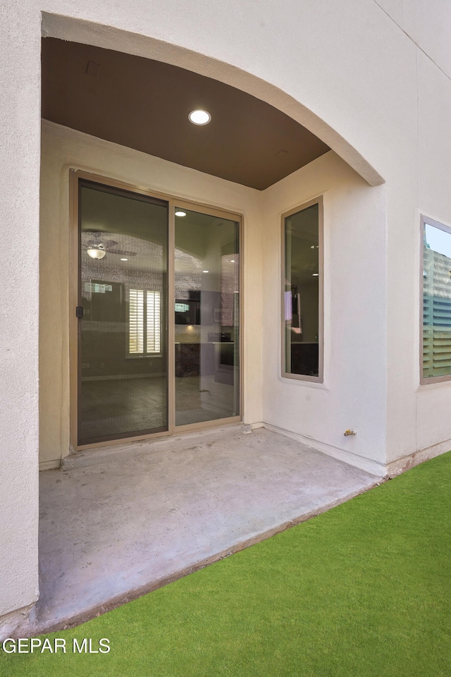 property entrance with a patio area and a yard