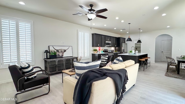 5844 Kobe Bryant St, El Paso, TX 79924 - living room featuring arched walkways, a ceiling fan, recessed lighting, light wood-style floors, and baseboards