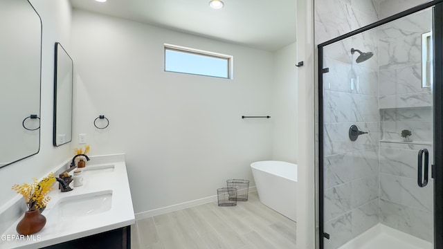 5844 Kobe Bryant St, El Paso, TX 79924 - full bath with double vanity, a freestanding tub, a stall shower, baseboards, and recessed lighting