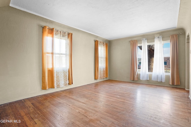 unfurnished room with hardwood / wood-style floors and a textured ceiling