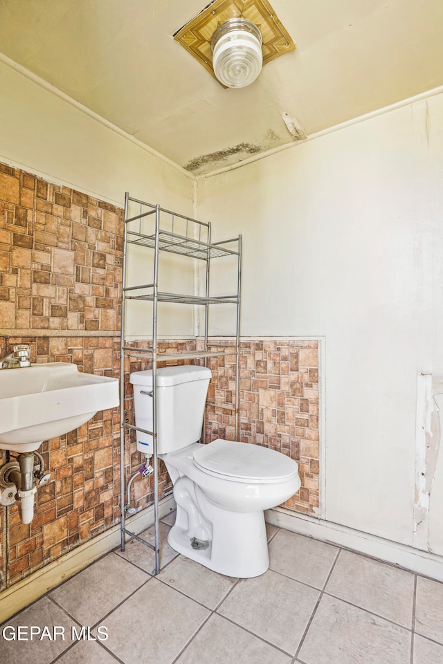 bathroom with tile walls, tile patterned floors, and toilet