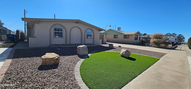 view of front of home with brick siding and a front yard