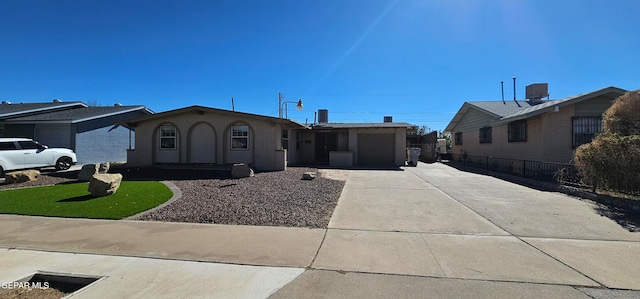 ranch-style house featuring a garage, driveway, brick siding, and cooling unit