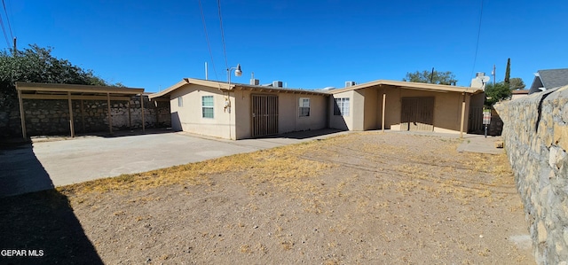 view of front of home with a patio area, fence, and stucco siding