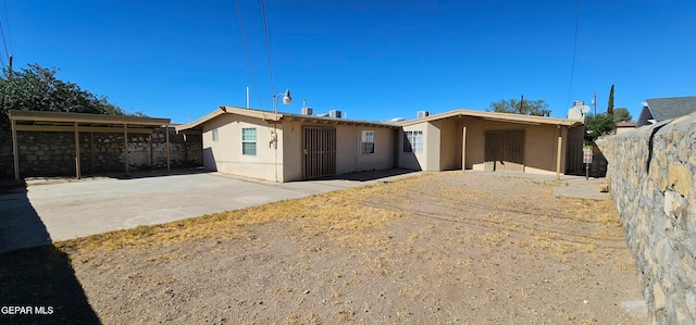 view of front of house featuring a patio area, fence, and stucco siding