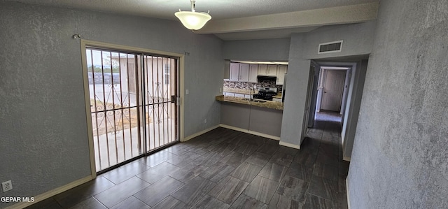 kitchen with vaulted ceiling with beams, dark wood-type flooring, pendant lighting, and appliances with stainless steel finishes