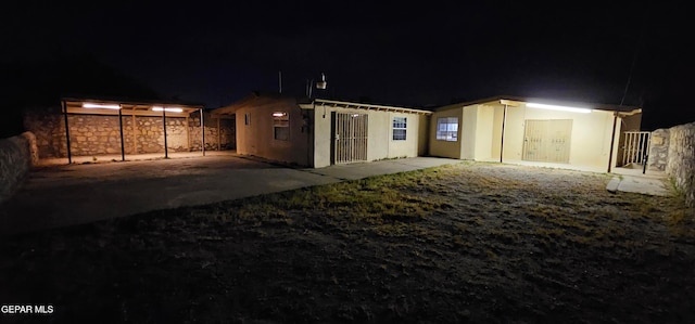 back of house at twilight featuring fence and stucco siding