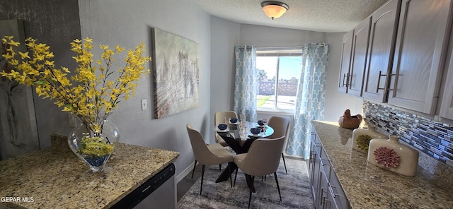 dining space featuring a textured wall, vaulted ceiling, and a textured ceiling