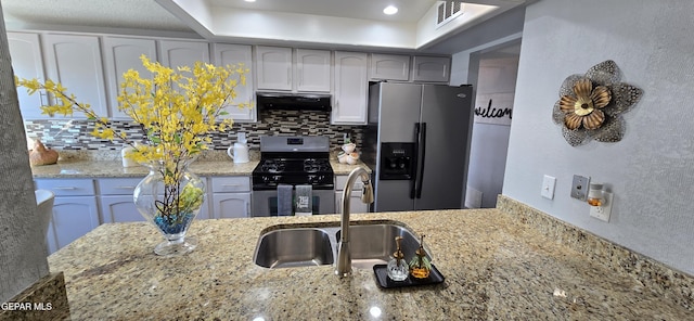 kitchen with stainless steel appliances, visible vents, backsplash, a sink, and under cabinet range hood