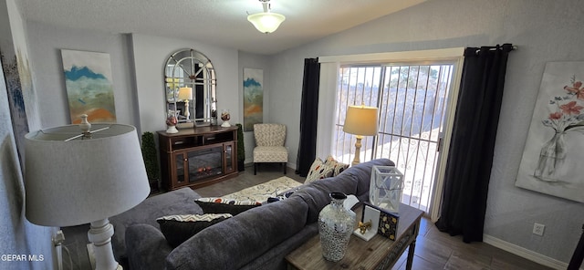 living area featuring lofted ceiling, plenty of natural light, wood finished floors, and baseboards