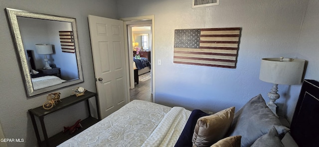 bedroom featuring visible vents and wood finished floors