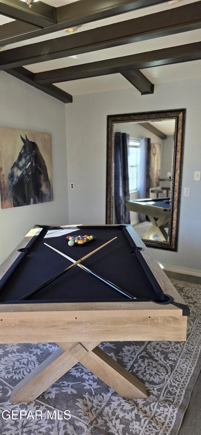 recreation room featuring beam ceiling and baseboards