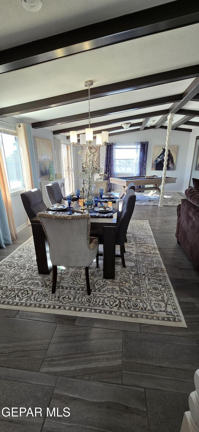 dining room featuring a notable chandelier, beamed ceiling, and baseboards