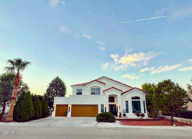 mediterranean / spanish home featuring a garage