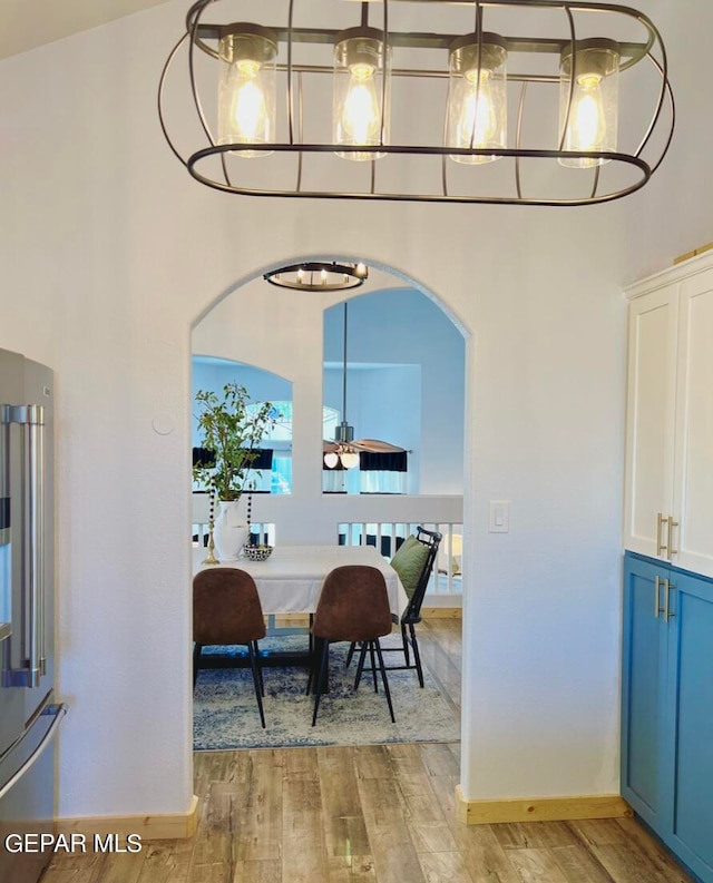 dining room featuring high vaulted ceiling and light wood-type flooring