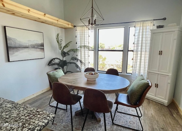 dining room with wood-type flooring and an inviting chandelier