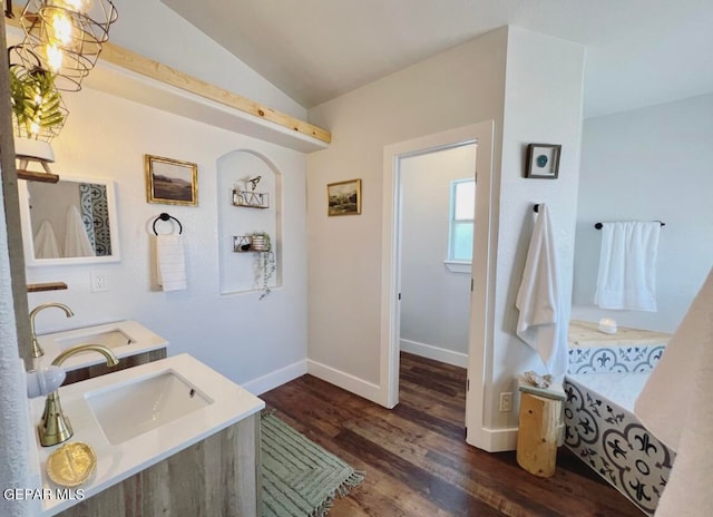 bathroom featuring vanity, hardwood / wood-style flooring, and vaulted ceiling