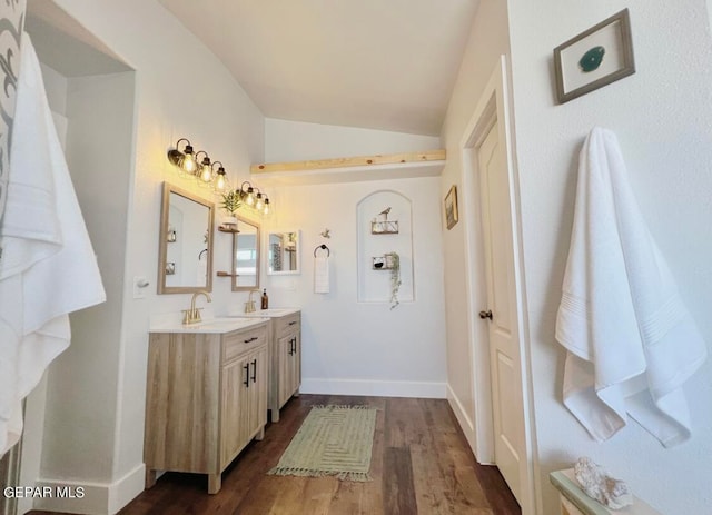 bathroom with vanity, hardwood / wood-style flooring, and lofted ceiling