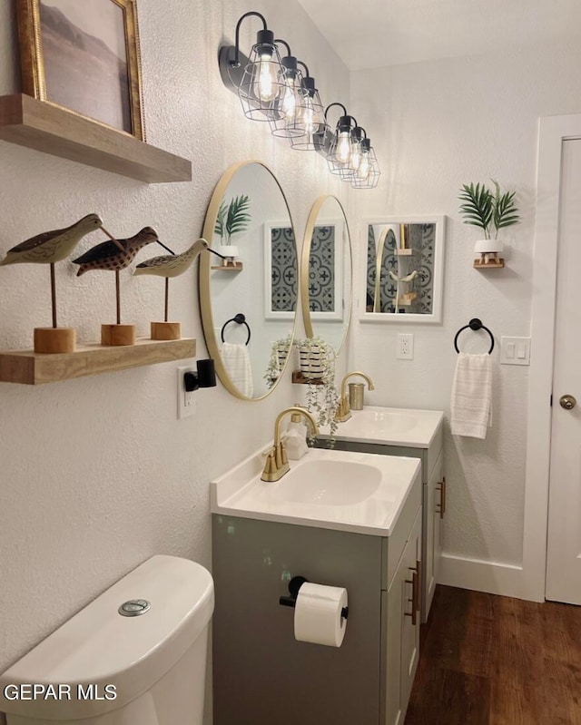 bathroom with toilet, hardwood / wood-style floors, and vanity