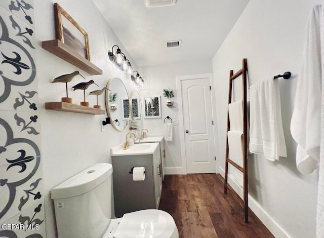 bathroom featuring vanity, toilet, and hardwood / wood-style floors