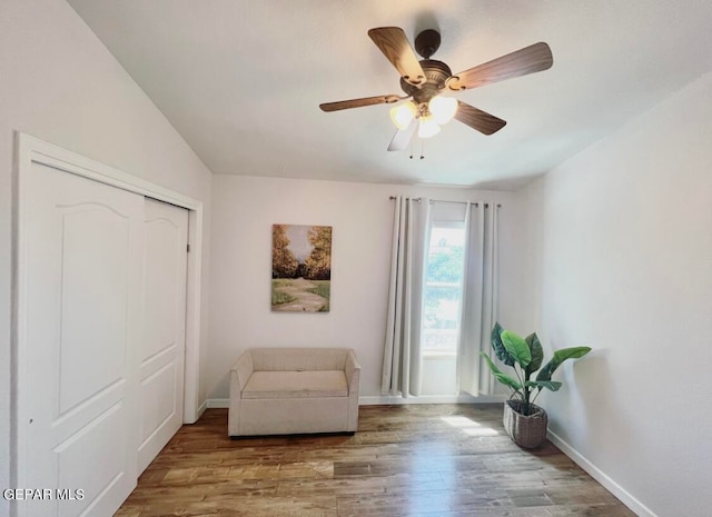 living area with light hardwood / wood-style floors, vaulted ceiling, and ceiling fan