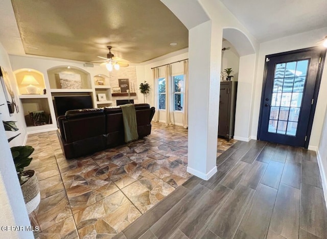 interior space with hardwood / wood-style flooring, ceiling fan, built in shelves, and plenty of natural light