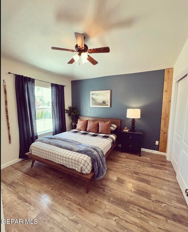 bedroom featuring hardwood / wood-style flooring, a closet, and ceiling fan